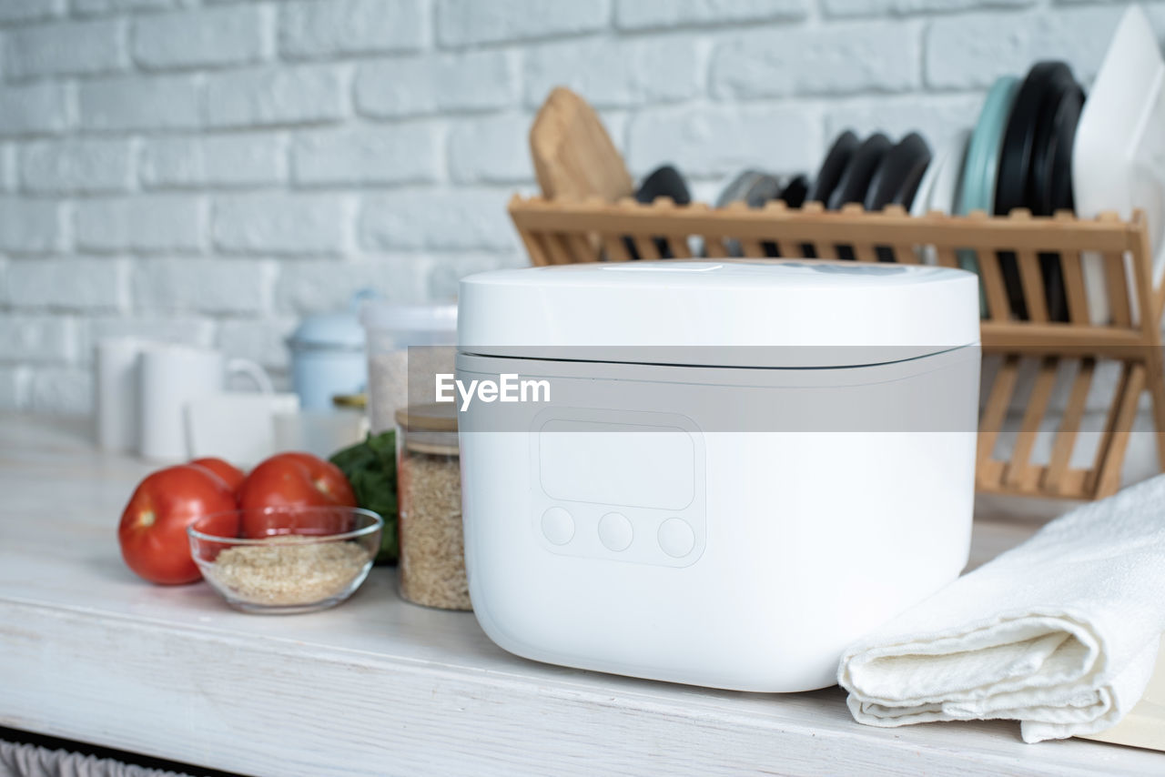 Kitchen appliances and devices. electric smart rice cooker on wooden counter-top in the kitchen