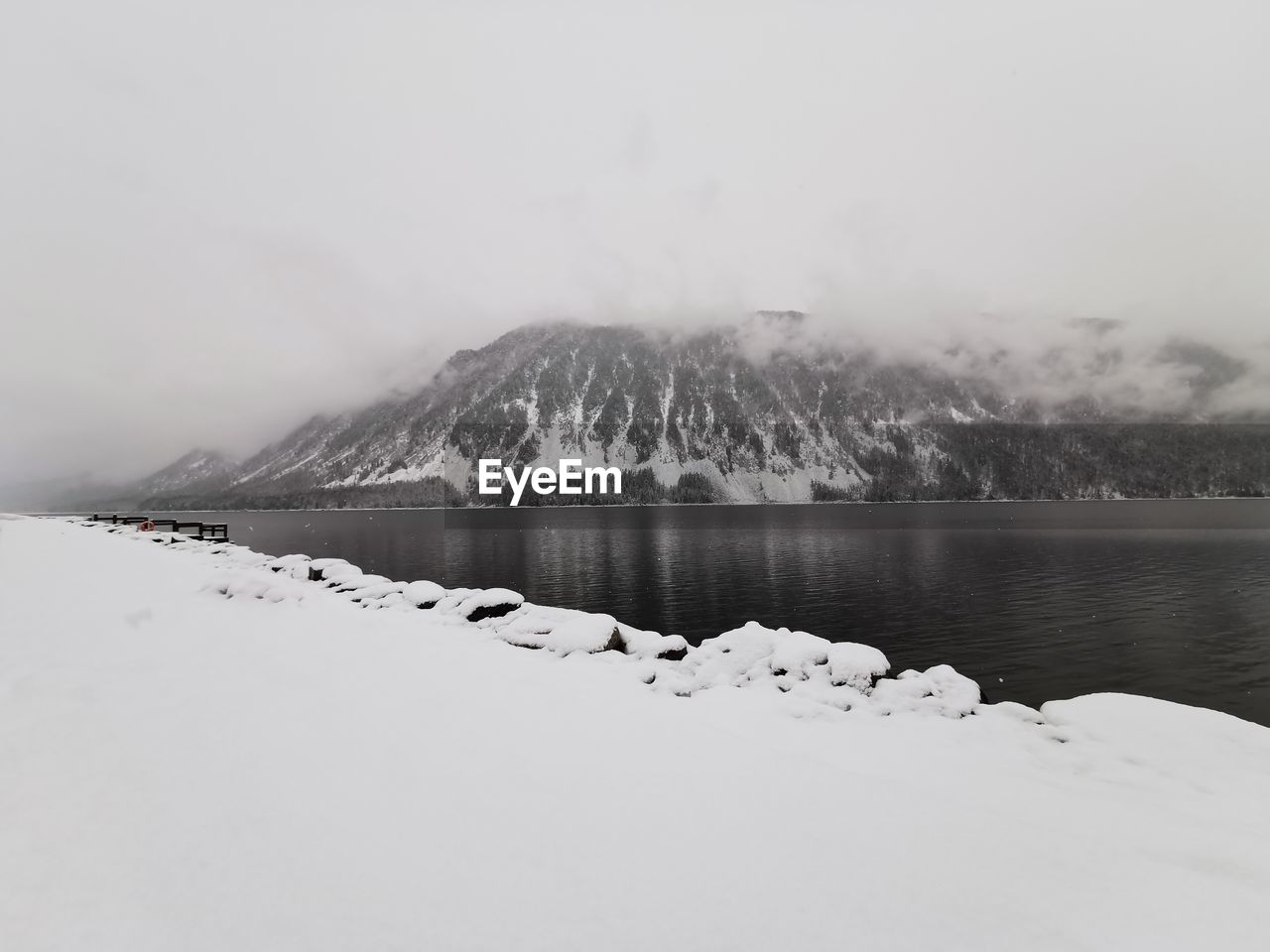 Scenic view of lake by snowcapped mountains against sky