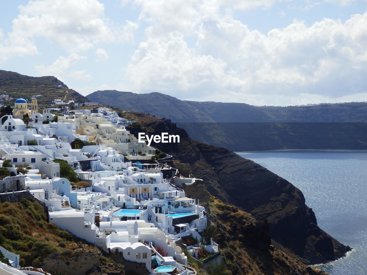 Scenic view of santorini by aegean sea against mountains