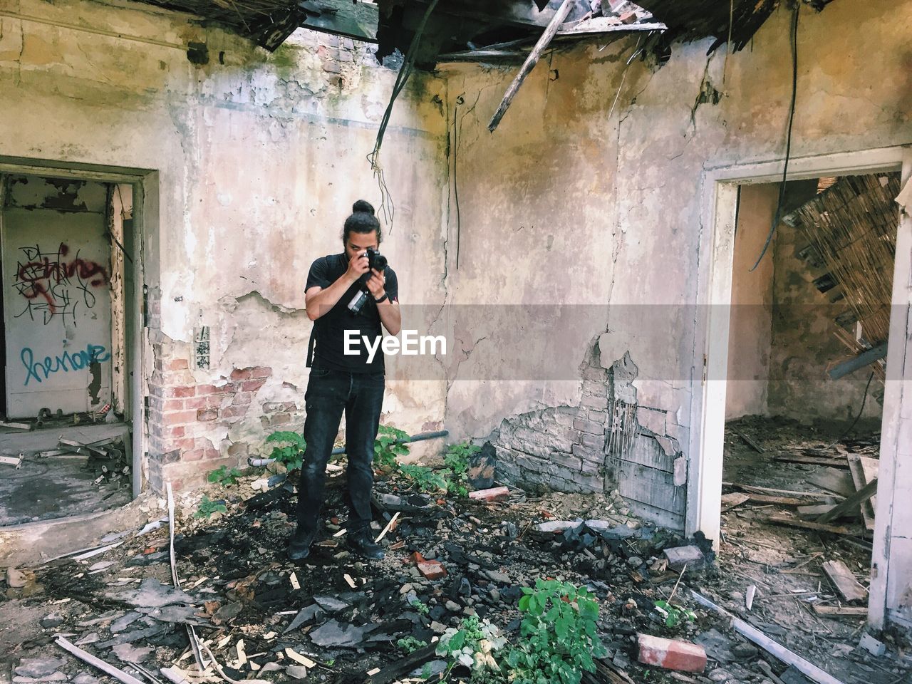 Young man photographing in abandoned house