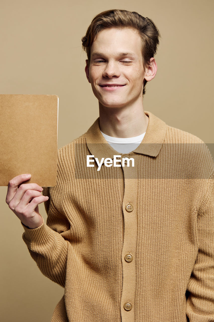 portrait of young man holding paper