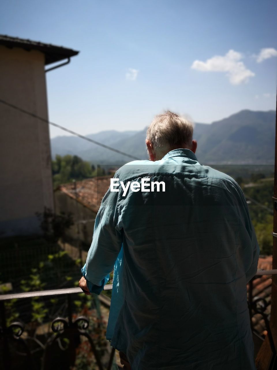 Rear view of man standing on balcony