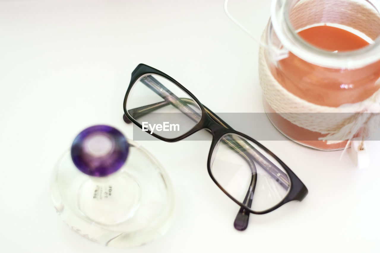 HIGH ANGLE VIEW OF EYEGLASSES ON GLASS