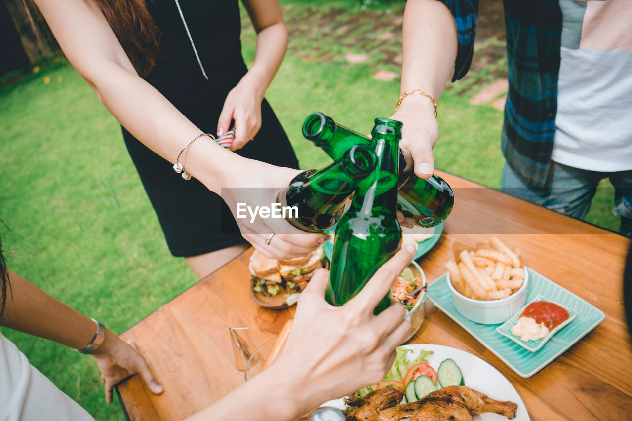 Midsection of woman holding drink on table