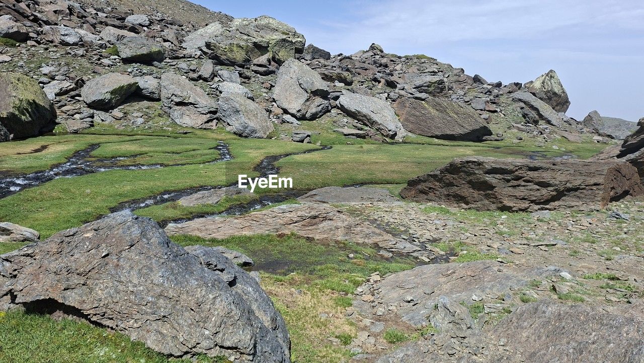landscape, environment, rock, scenics - nature, nature, mountain range, mountain, sky, ridge, beauty in nature, geology, land, wilderness, plateau, plant, no people, grass, tranquility, travel destinations, non-urban scene, travel, walking, valley, tranquil scene, adventure, day, outdoors, activity, terrain, mountain pass, cloud, rock formation, green, water, tourism, leisure activity, tree, rural scene, cliff, outdoor pursuit