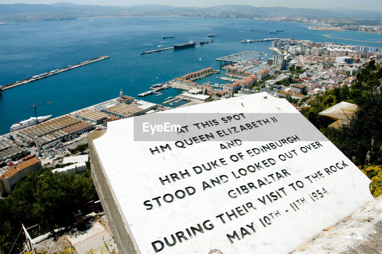 HIGH ANGLE VIEW OF TEXT ON SEA BY CITY