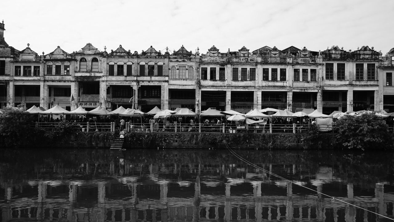 Building by lake against sky