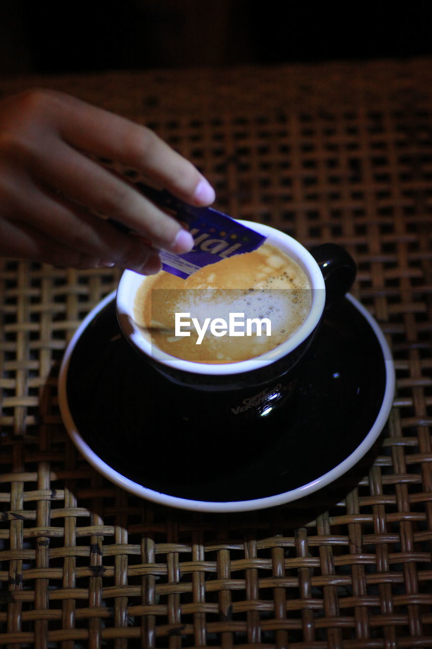 CLOSE-UP OF HAND HOLDING COFFEE CUP