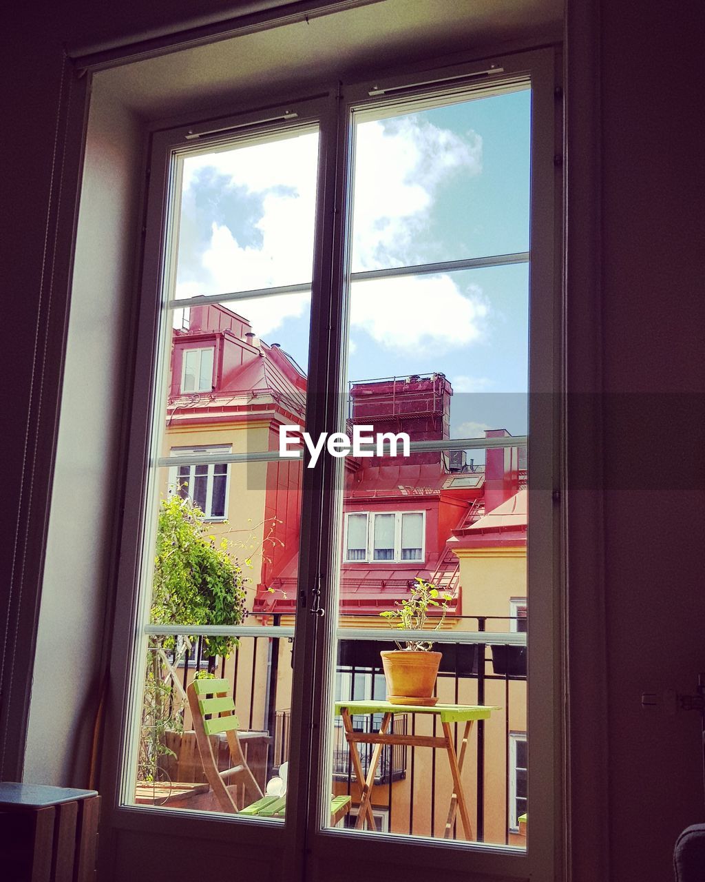 BUILDINGS AGAINST SKY SEEN THROUGH WINDOW