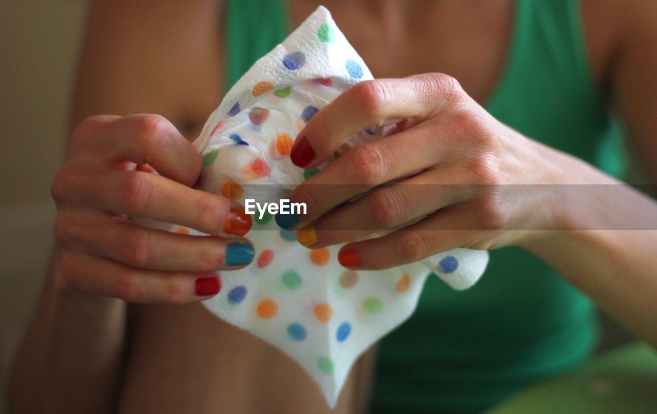 Midsection of woman holding multi colored tissue paper
