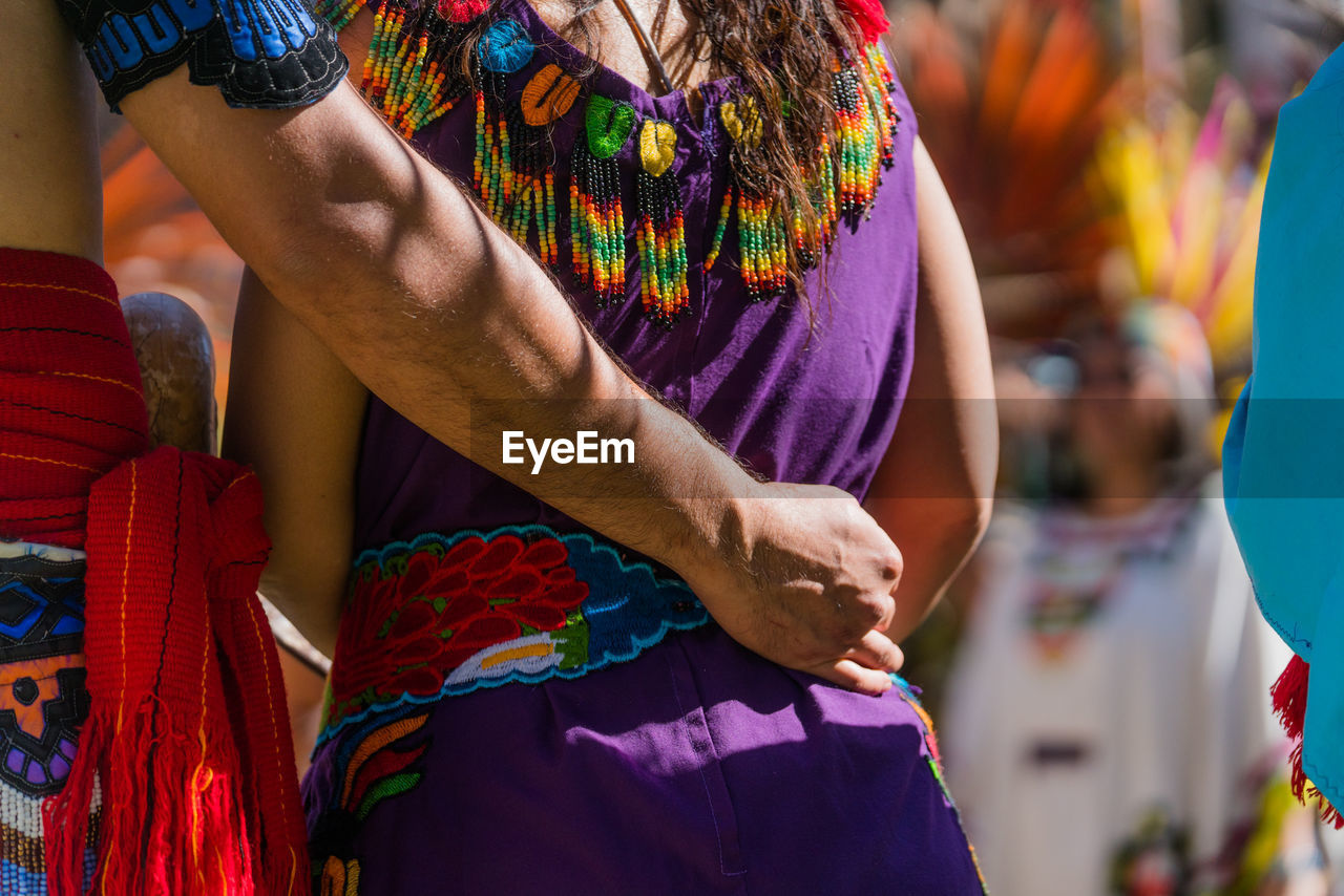 Cropped image of man arm around woman