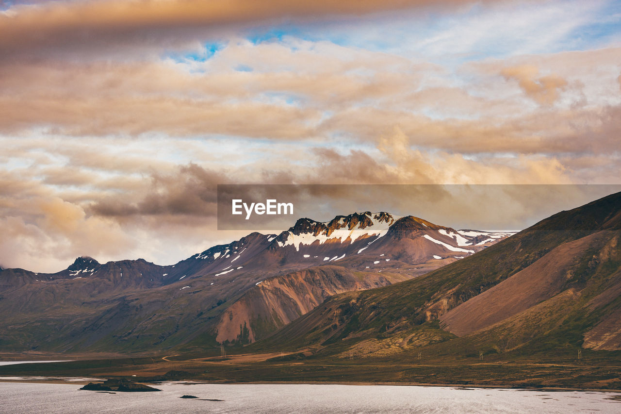 Scenic view of lake by mountains against sky