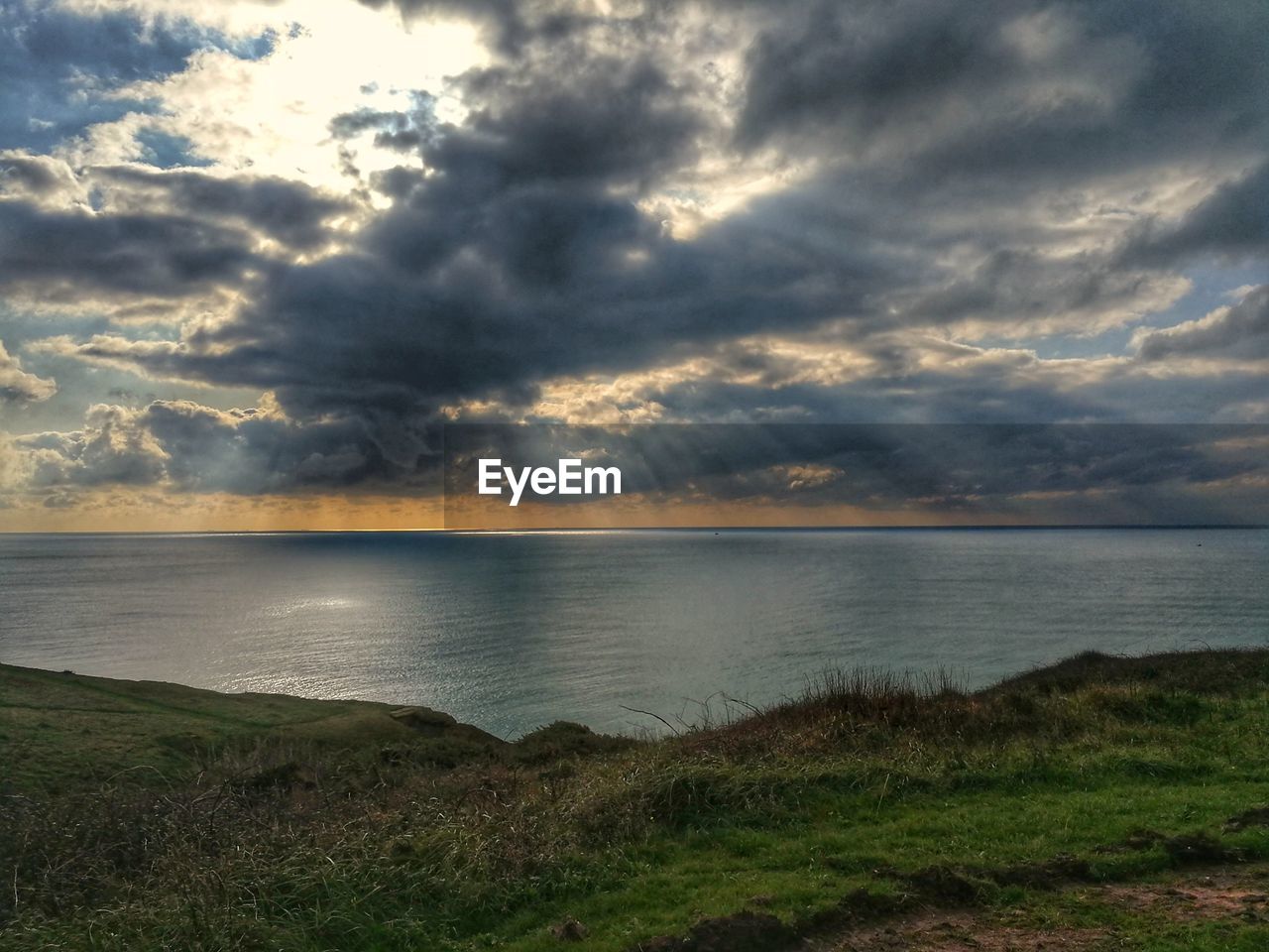 SCENIC VIEW OF BEACH AGAINST CLOUDY SKY