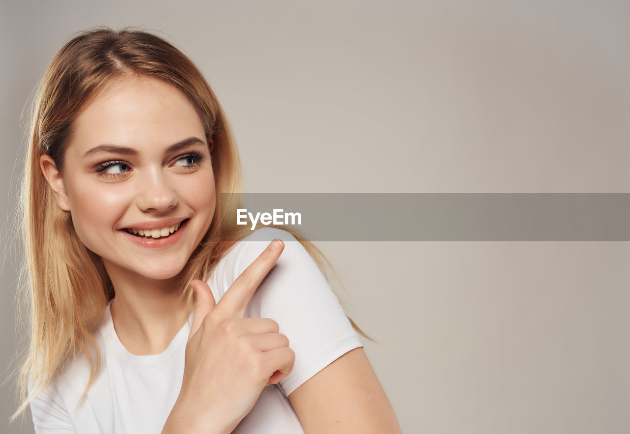 PORTRAIT OF A SMILING YOUNG WOMAN