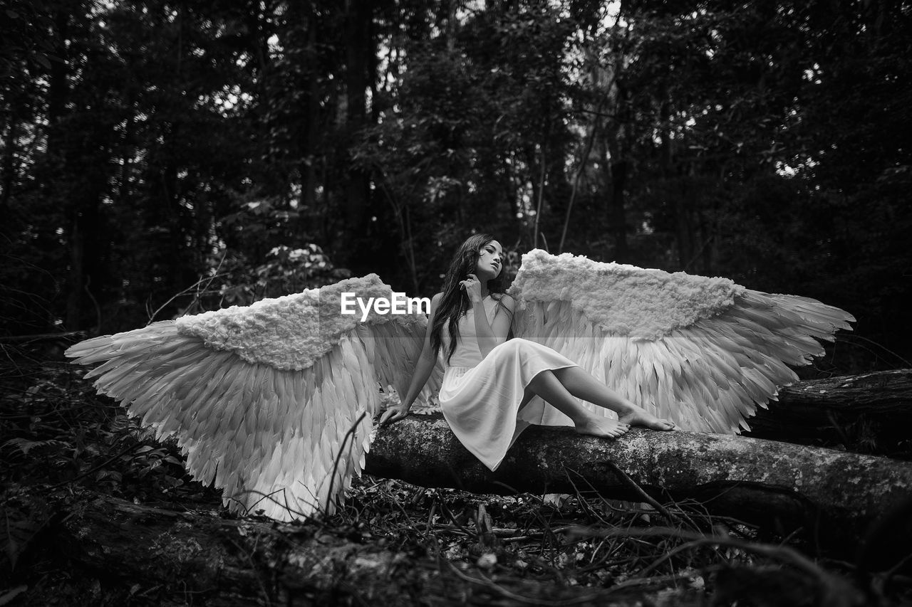 Rear view of woman standing in forest