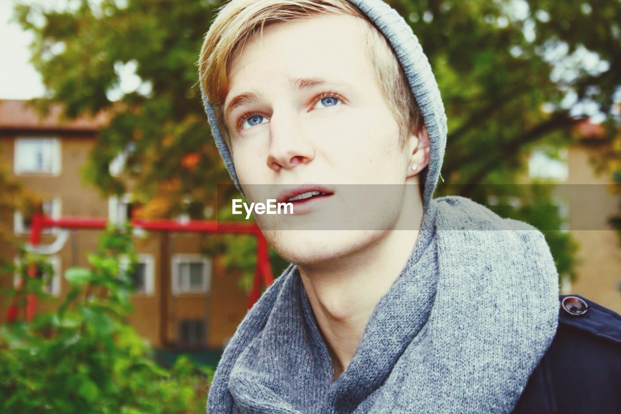 Close-up of a young man with blue eyes looking up