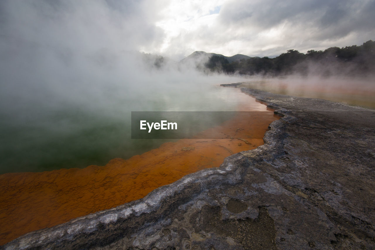 Scenic view of steam emitting from hot spring