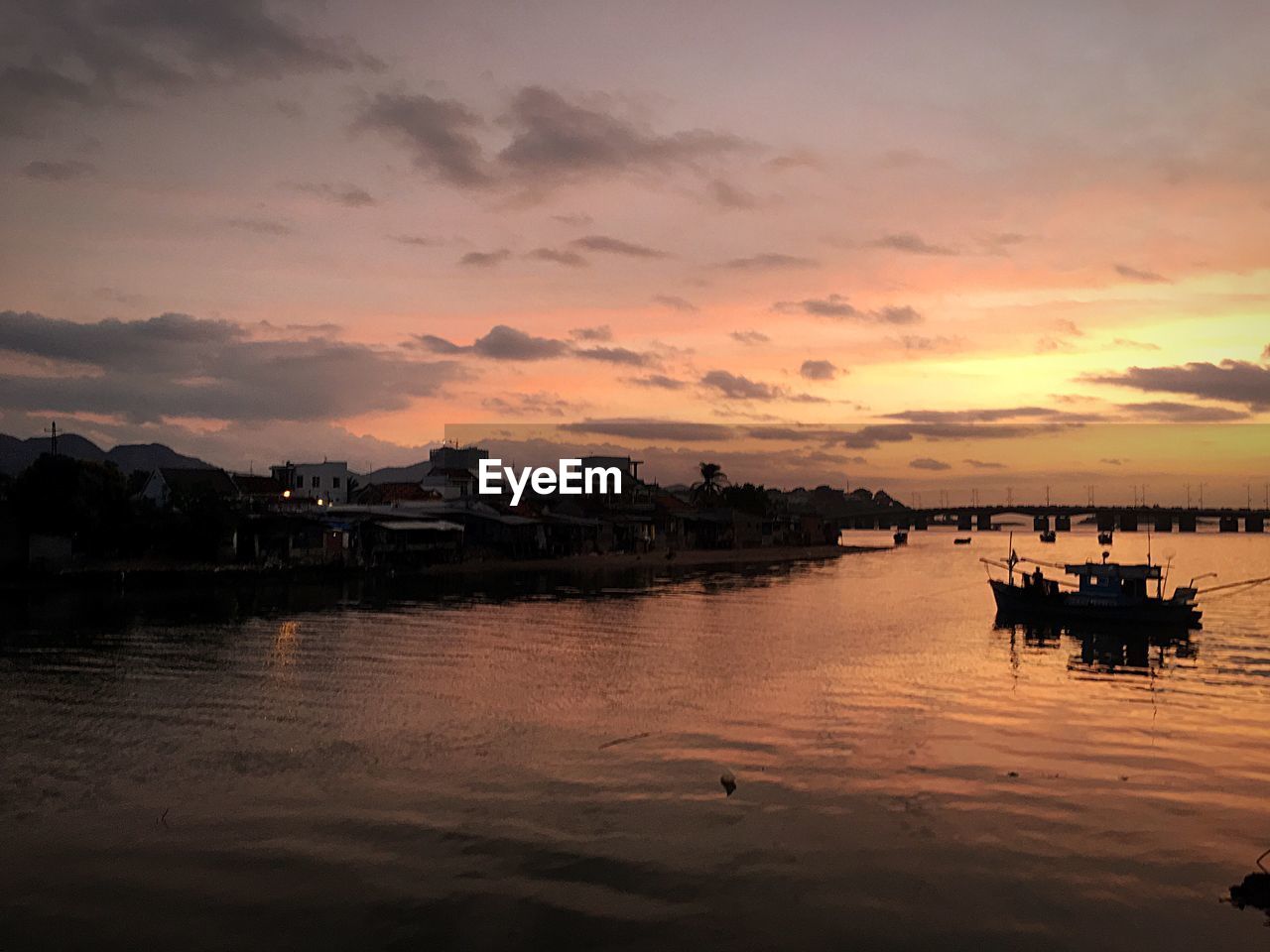 Silhouette boats in sea against orange sky