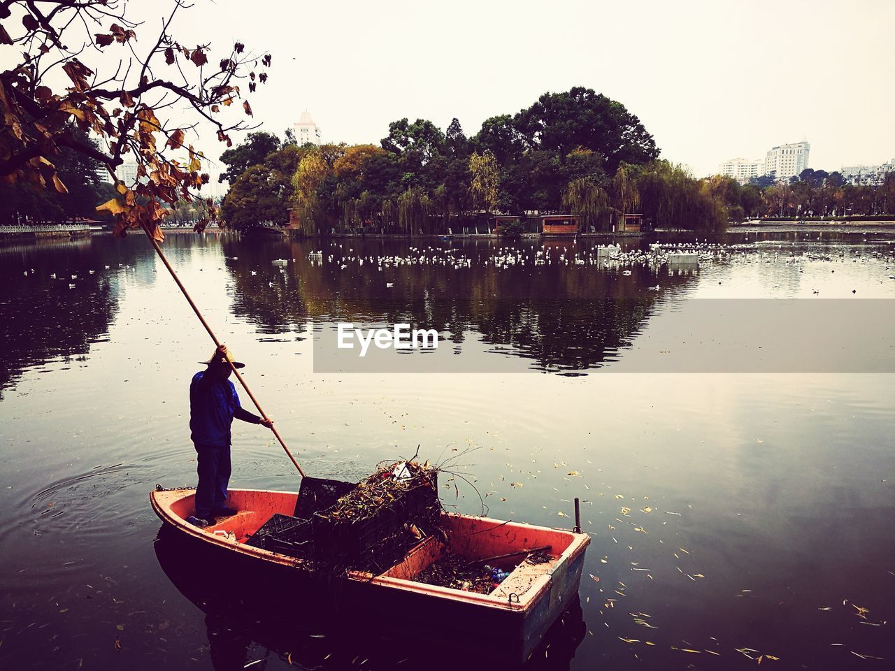 MAN STANDING ON LAKE AGAINST SKY