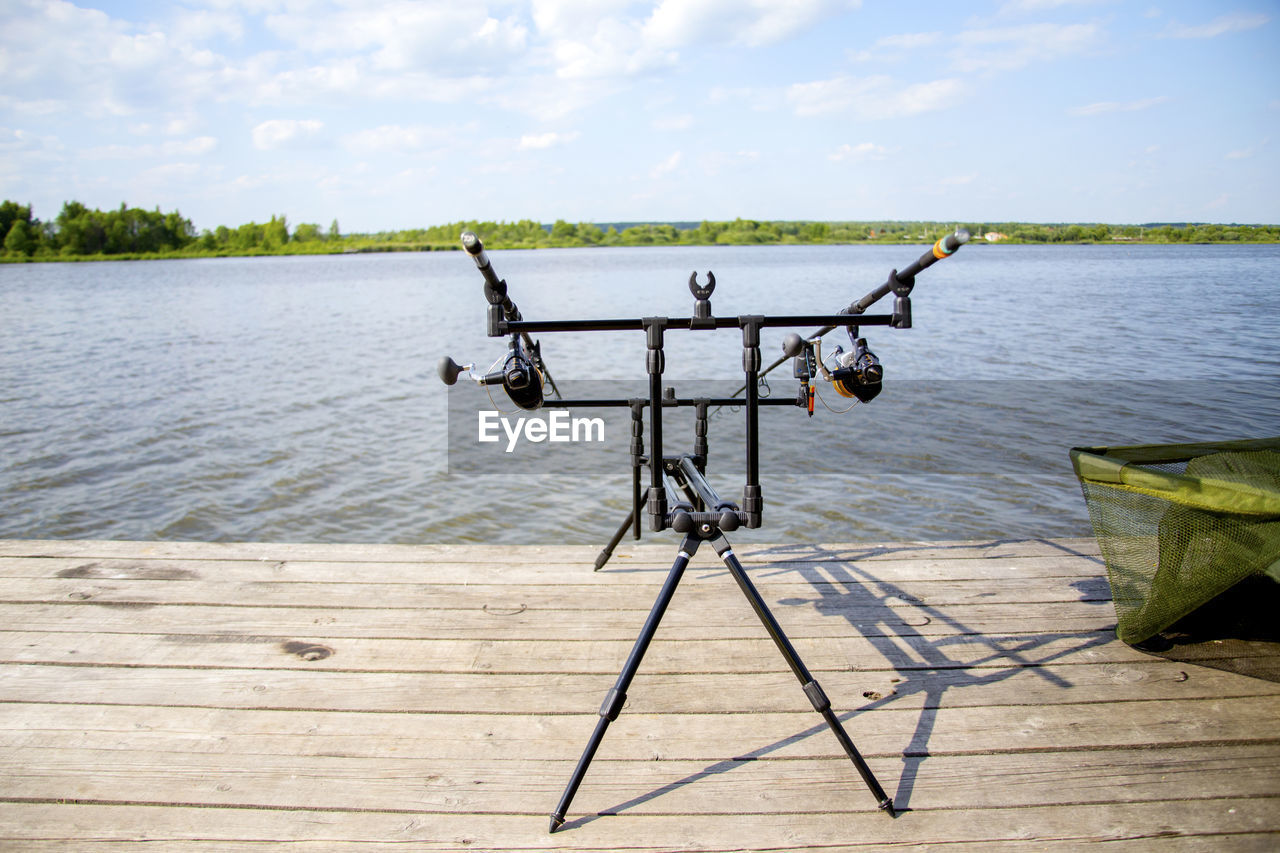 Fishing rods on pier over lake