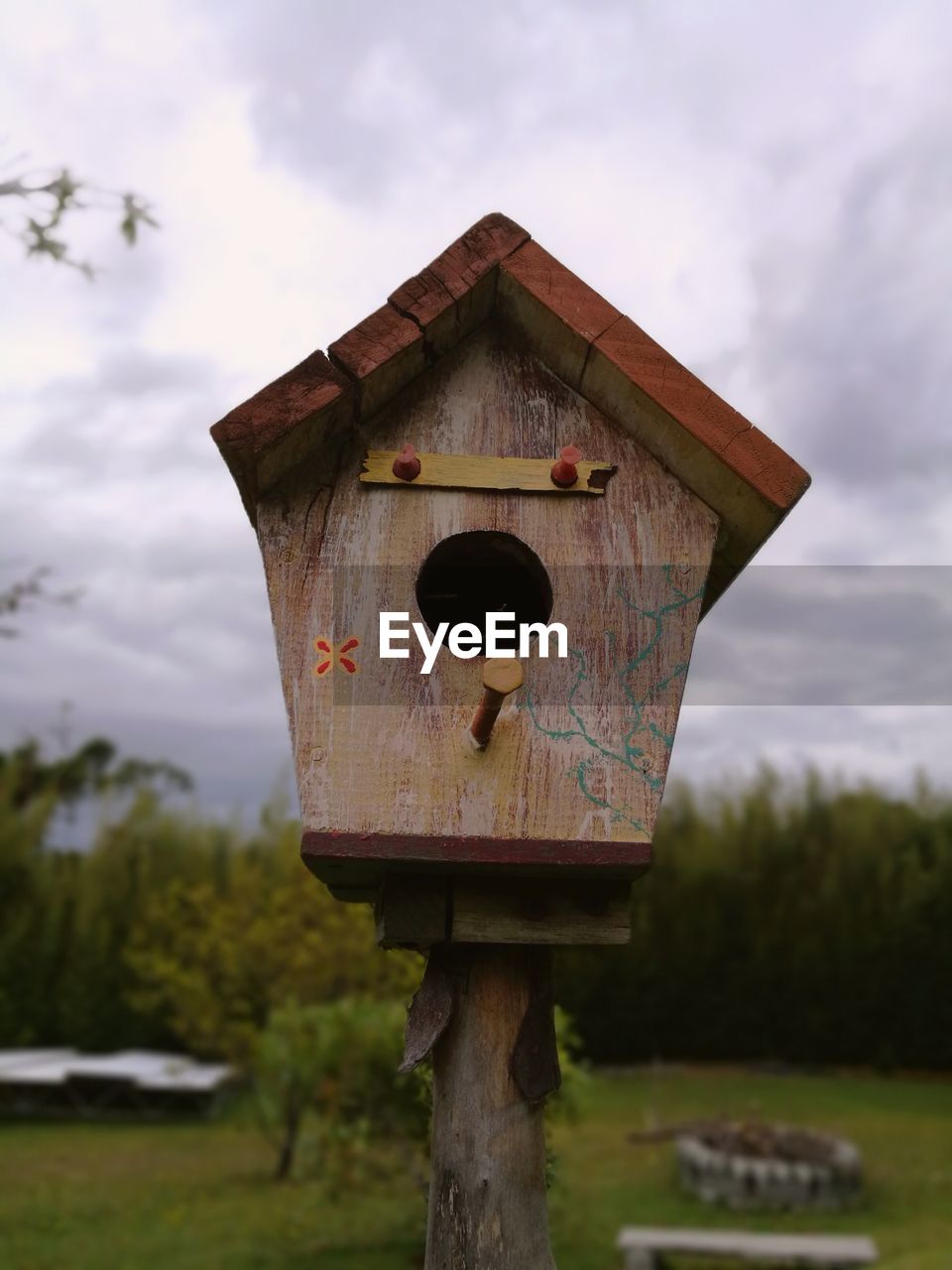 Close-up of birdhouse on wooden post against sky