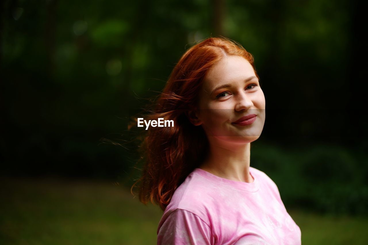 PORTRAIT OF SMILING YOUNG WOMAN
