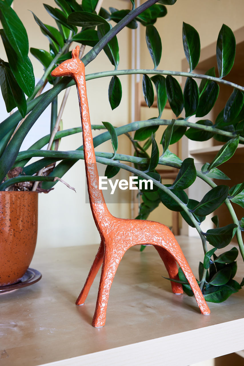 Statuette of giraffe and house plant