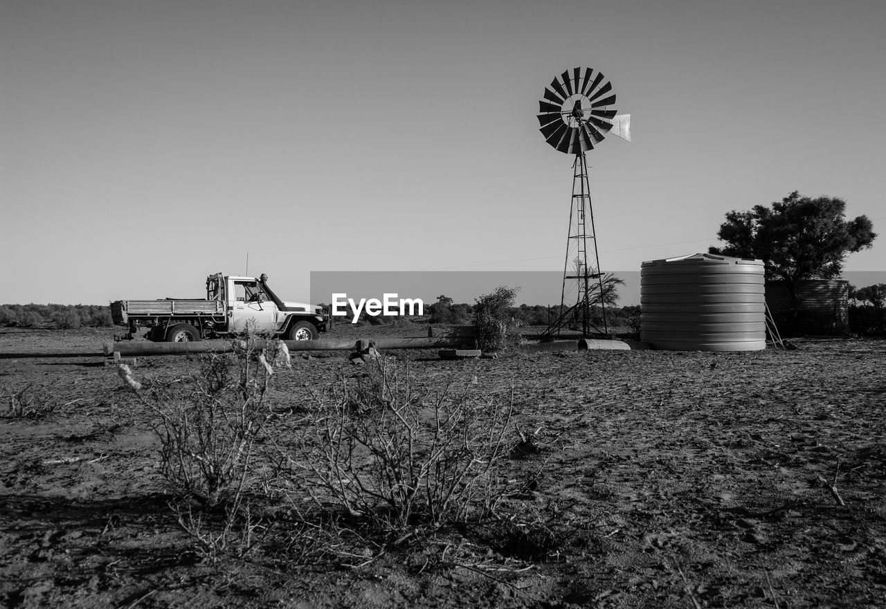 Windmill on field against clear sky