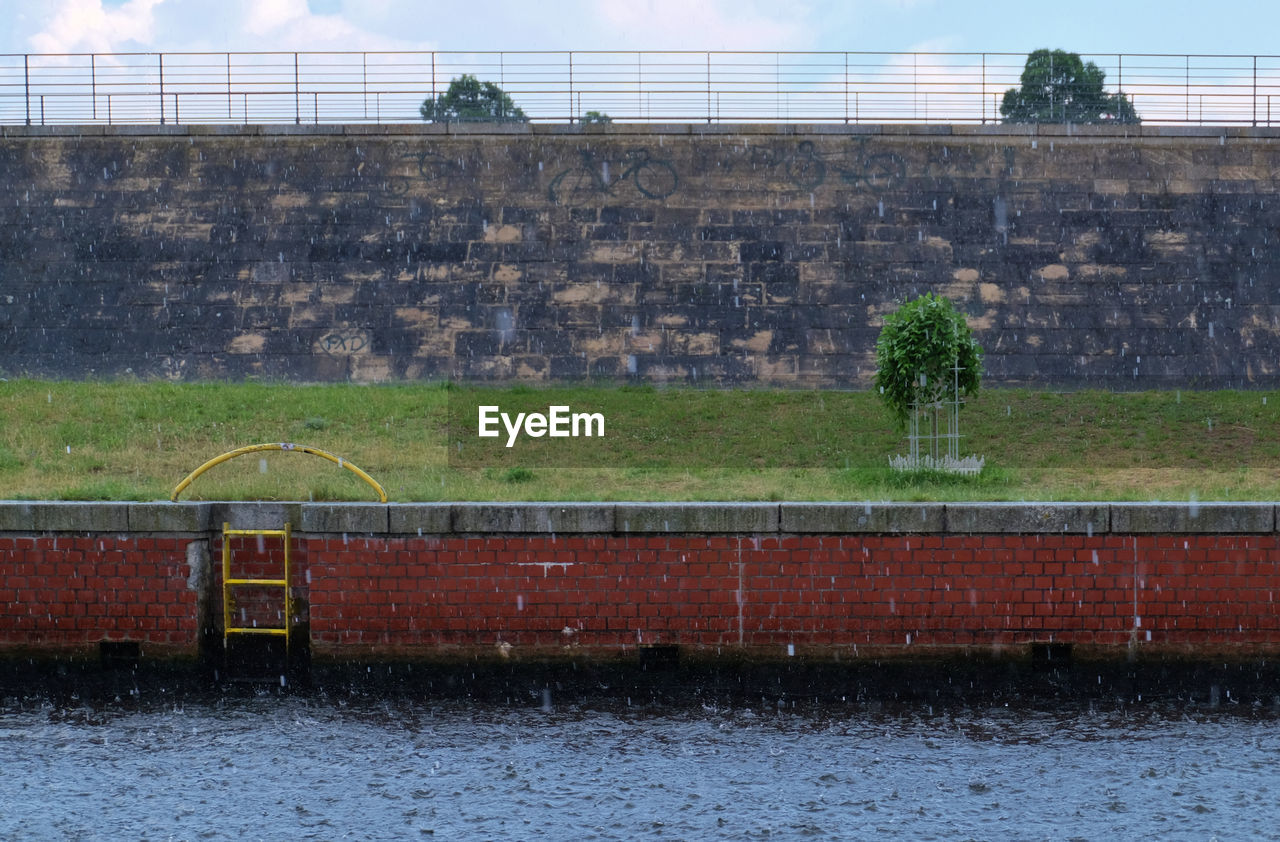 Canal by wall during rainy season