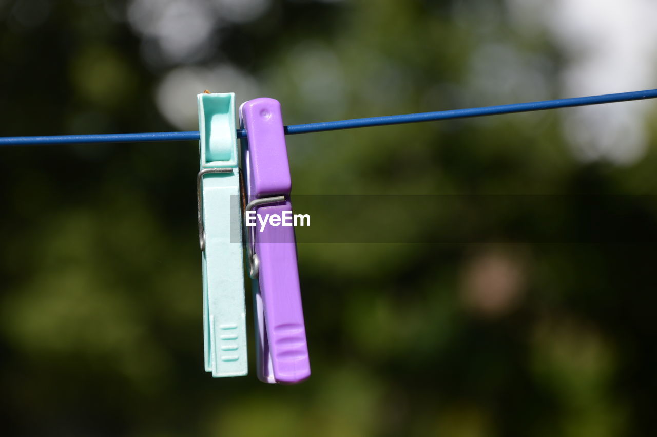 hanging, clothesline, clothespin, focus on foreground, laundry, green, no people, rope, day, nature, close-up, outdoors, drying, clothing, chores, multi colored