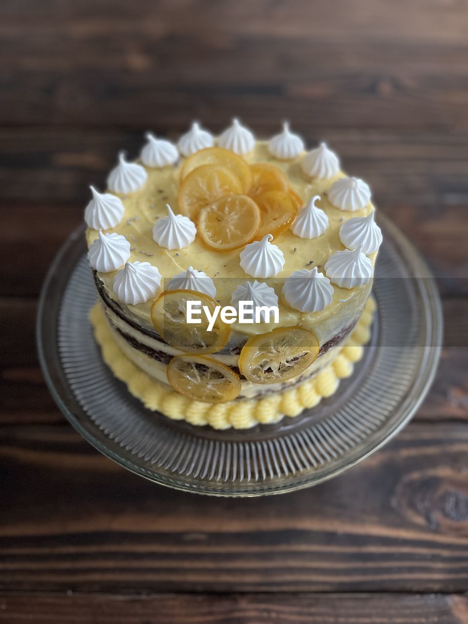 food and drink, food, cake, sweet food, icing, dessert, sweet, freshness, wood, baked, birthday cake, table, flower, yellow, indoors, plate, no people, temptation, fruit, cupcake, celebration, close-up, high angle view, still life, cake decorating, decoration, healthy eating, flowering plant