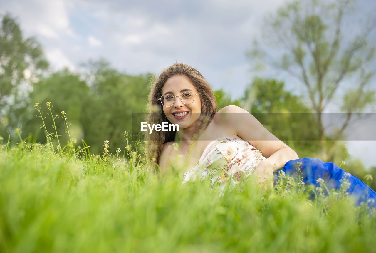 portrait of young woman standing amidst plants