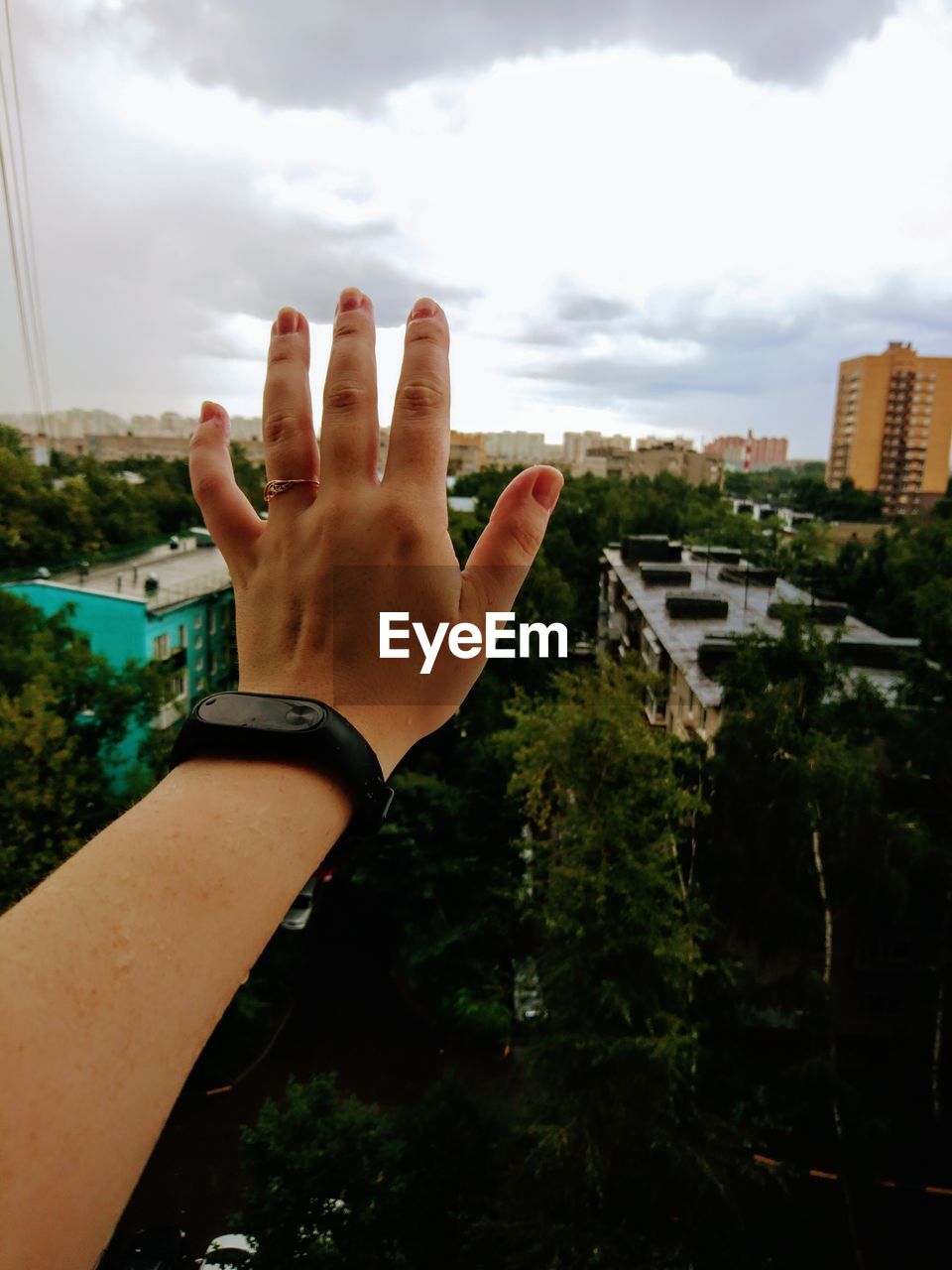 CLOSE-UP OF MAN WITH HAND AGAINST SKY