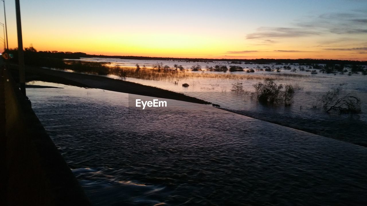 Scenic view of river at sunset