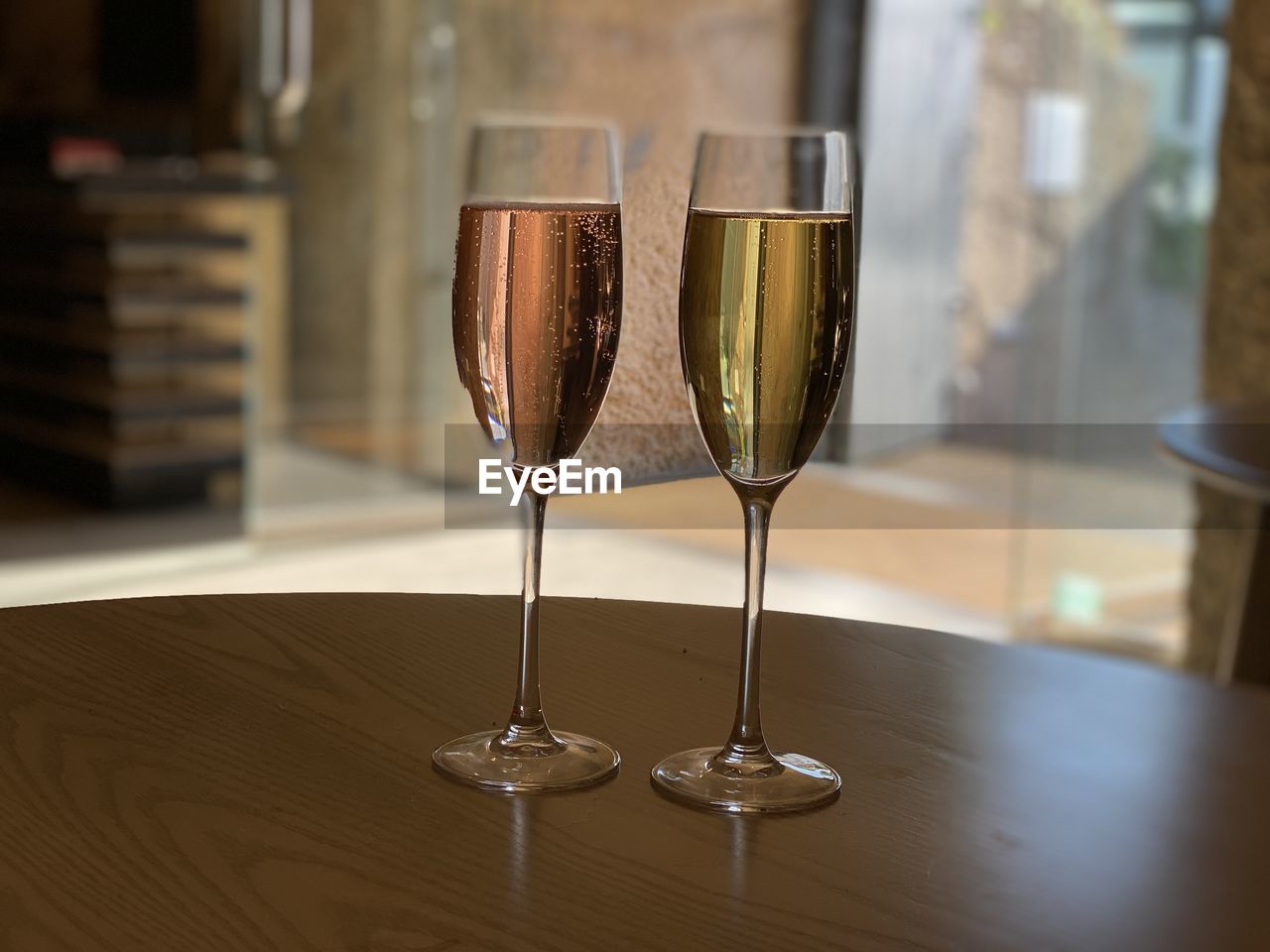 CLOSE-UP OF WINE GLASSES ON GLASS TABLE