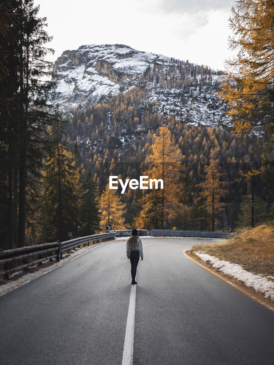 Woman walking on road during autumn