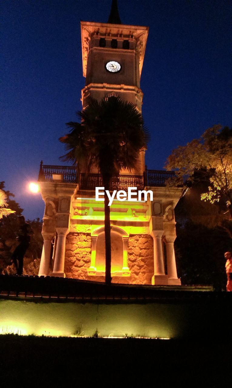 LOW ANGLE VIEW OF ILLUMINATED BUILT STRUCTURE AT NIGHT