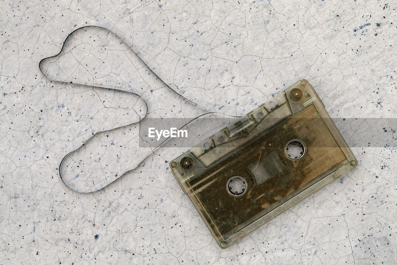 Directly above shot of audio cassette on cracked surface