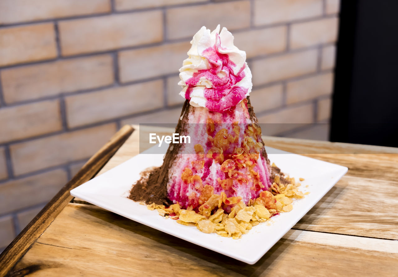 CLOSE-UP OF CHOCOLATE CAKE ON PINK TABLE