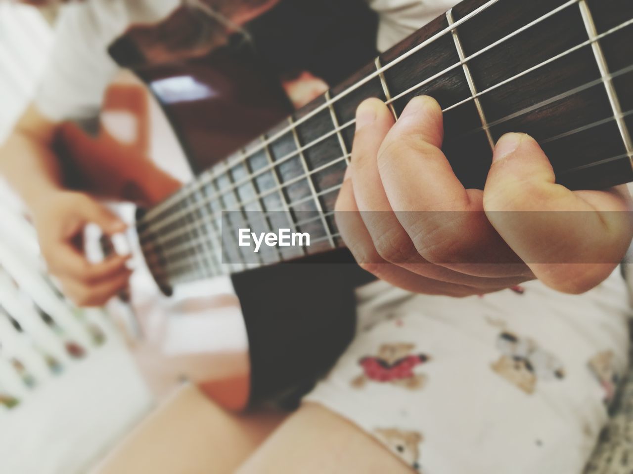 string instrument, musical instrument, guitar, arts culture and entertainment, music, playing, human hand, hand, musical equipment, real people, string, one person, indoors, musical instrument string, selective focus, artist, lifestyles, musician, leisure activity, plucking an instrument, finger