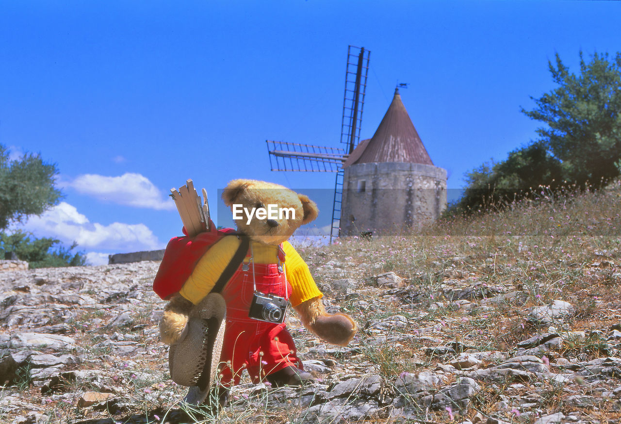 BOY WITH TOY ON FIELD AGAINST SKY