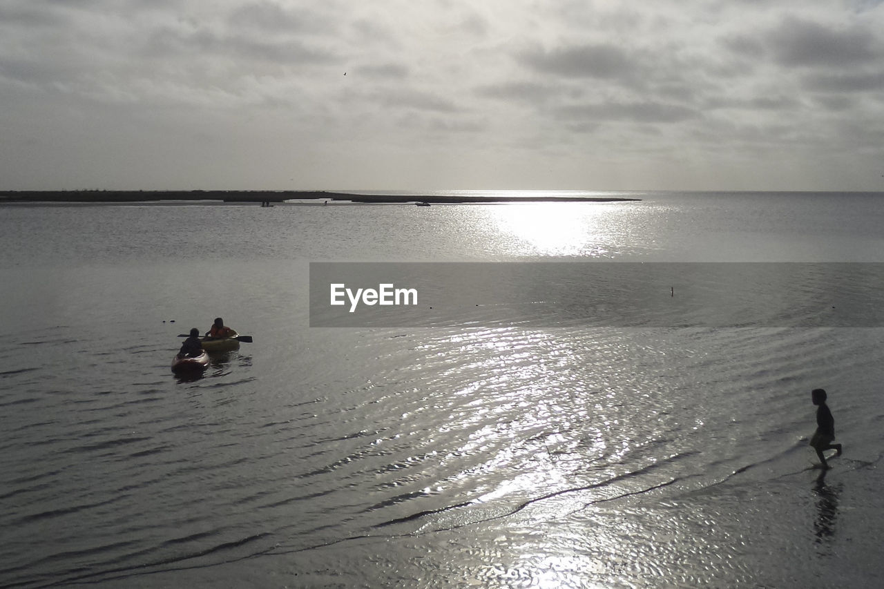 PEOPLE ON SEA AGAINST SKY