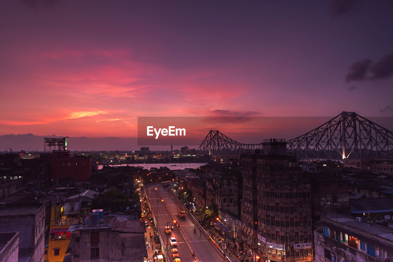 High angle view of illuminated city against sky at sunset