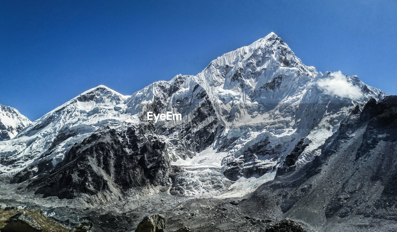 Scenic view of snowcapped mountains against clear blue sky