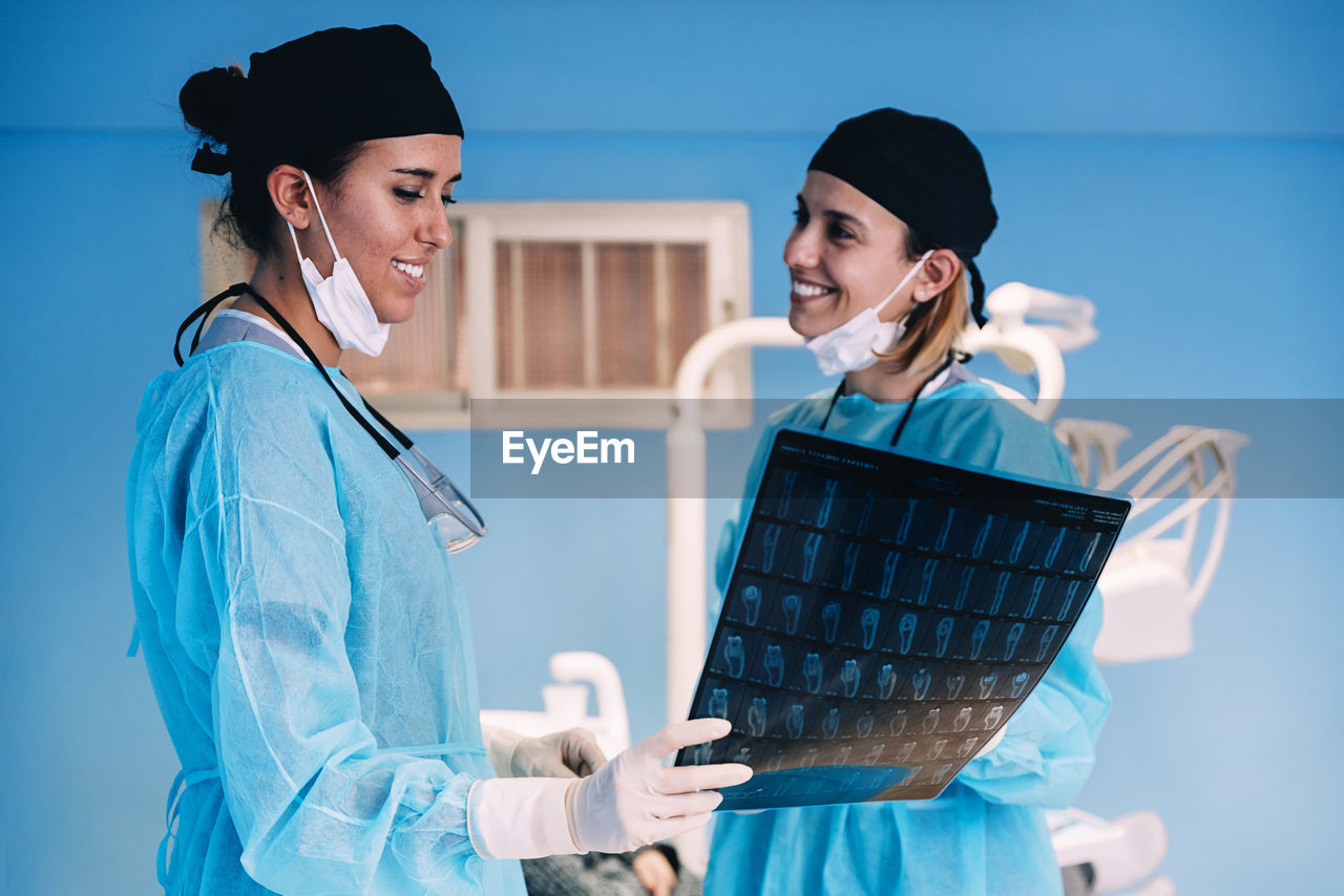 Surgeons examining x-ray image while standing in operating room