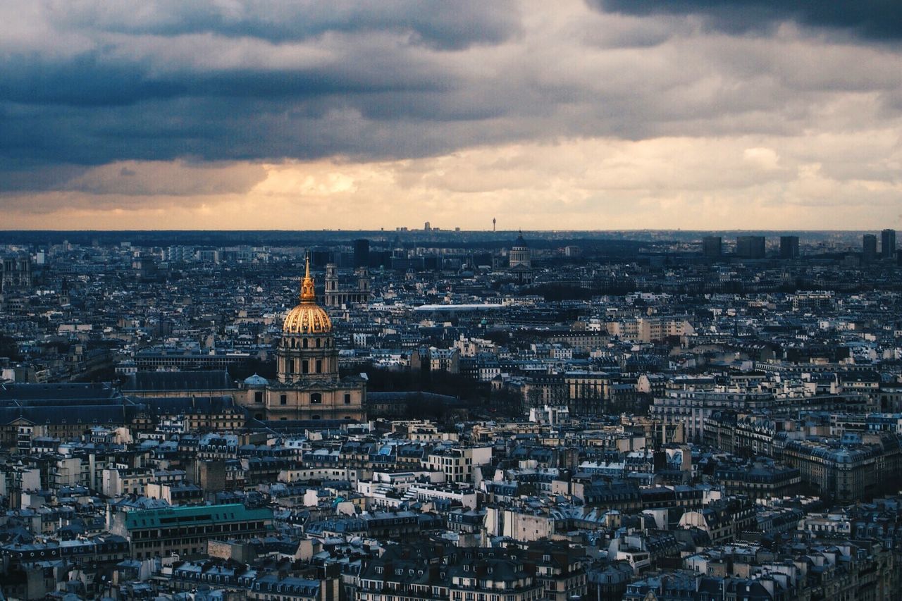 Cityscape against cloudy sky during sunset