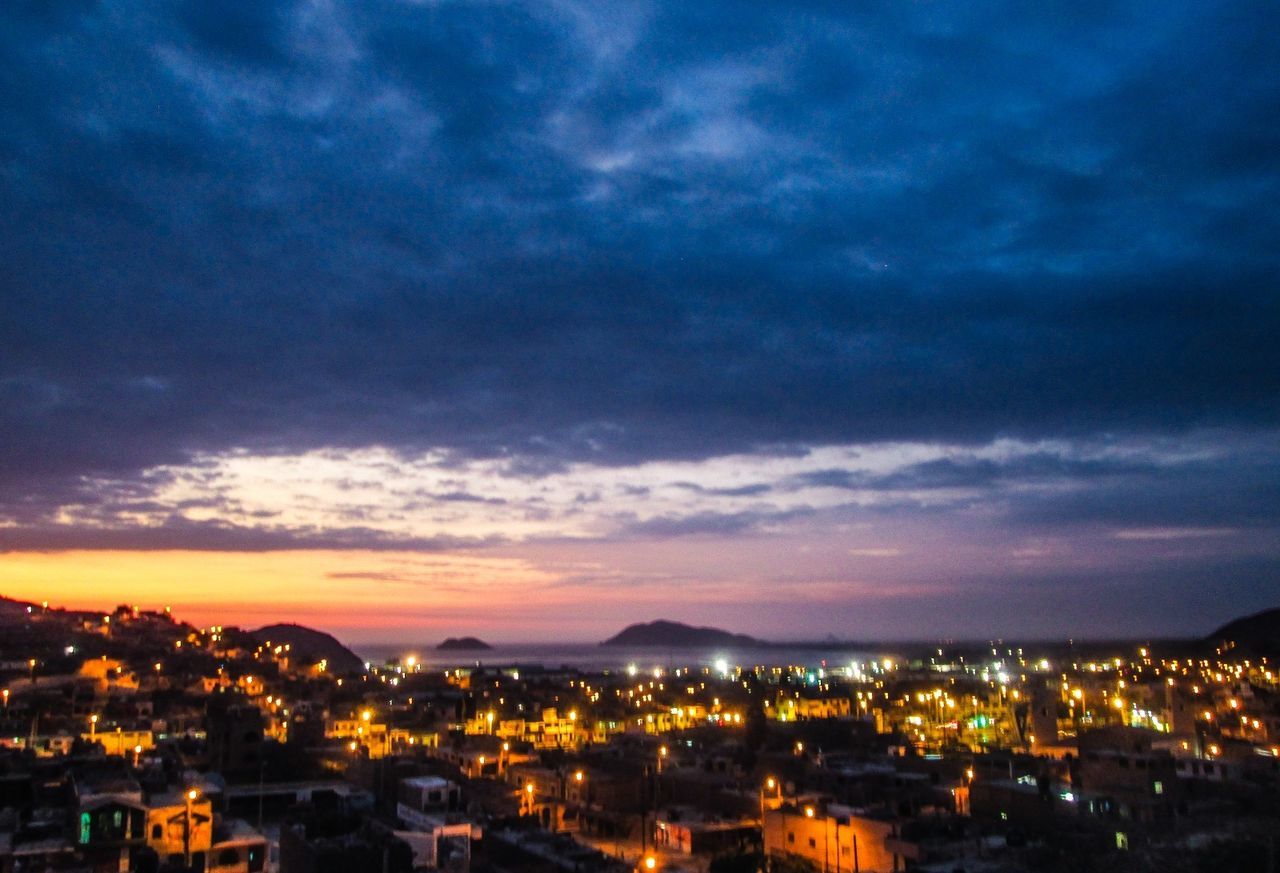 CITYSCAPE AGAINST CLOUDY SKY AT DUSK