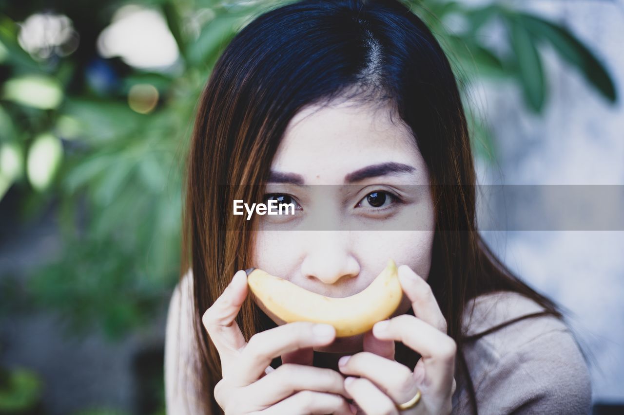 Portrait of woman holding banana