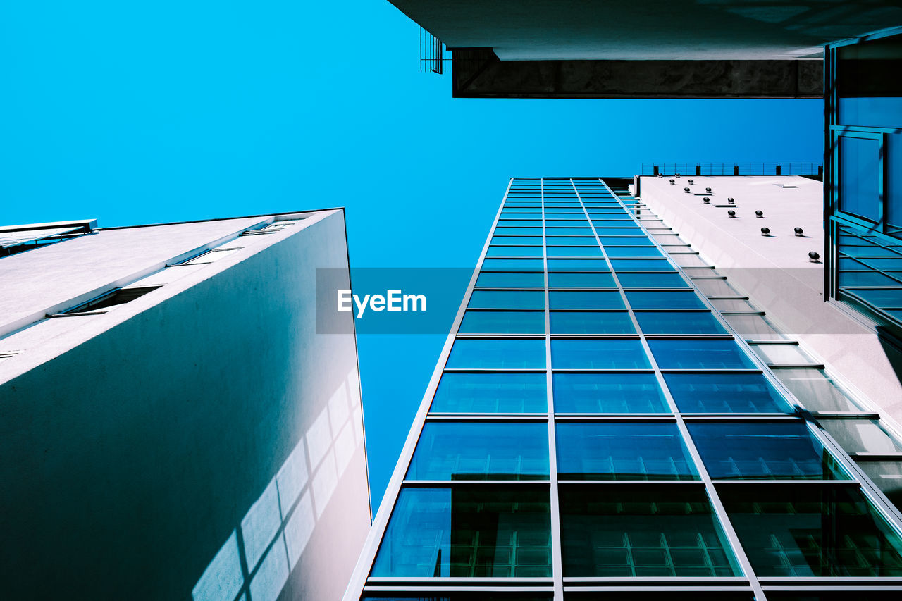 Low angle view of modern building against clear blue sky