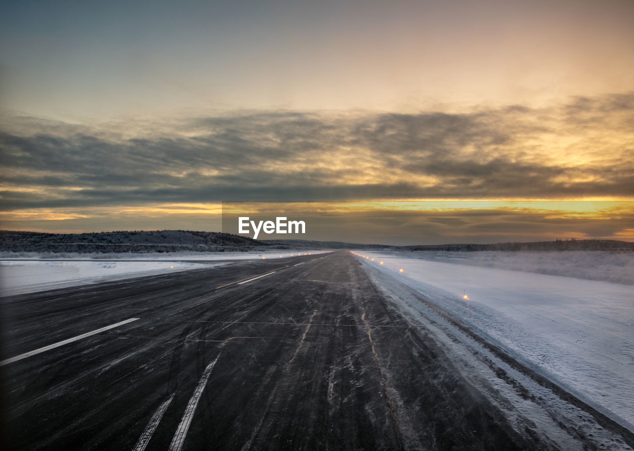 Airport runway in the far north at dawn surrounded by snow